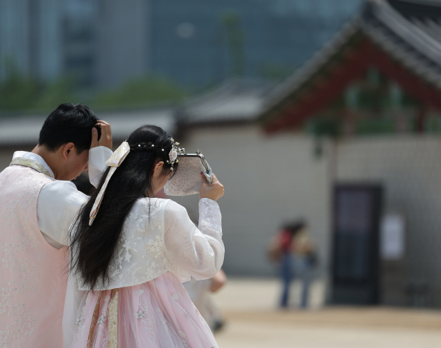 전국적으로 초여름 날씨를 보인 지난 24일 서울 종로구 경복궁을 찾은 외국인이 가방으로 햇빛을 가리고 있다. 연합뉴스