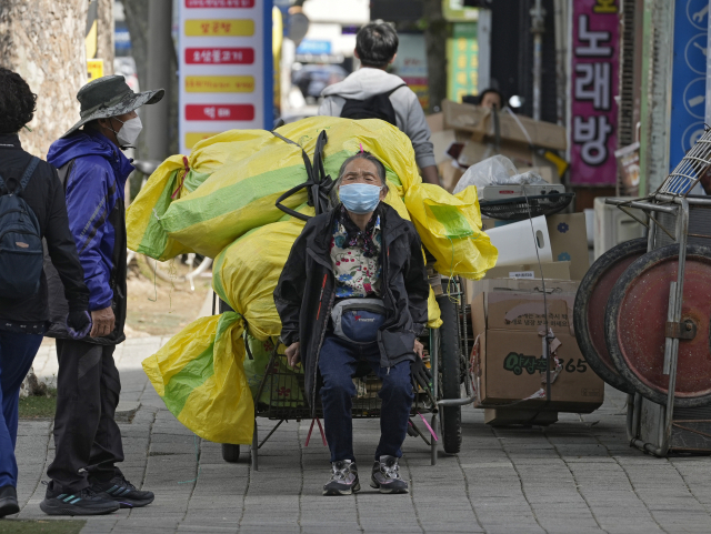 어버이날인 지난 달 8일 대구 동구의 한 재활용센터 인근에서 폐지를 옮기던 어르신이 손수레에 앉아 휴식을 취하고 있다. 김영진 기자 kyjmaeil@imaeil.com