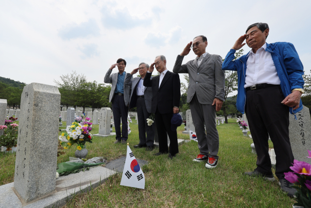 현충일을 하루 앞둔 5일 오후 서울 동작구 국립서울현충원을 찾은 참배객들이 전우의 묘역에서 경례하고 있다. 연합뉴스