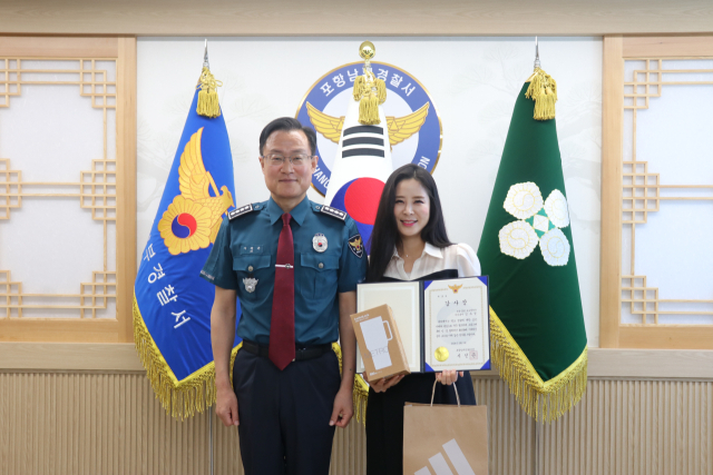 지난 5일 포항남부경찰서에서 김유정 포항CBS 아나운서가 시진곤 서장으로부터 감사장을 받고 있다. 포항남부경찰서 제공.