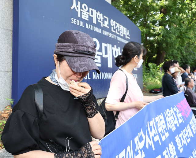 지난 12일 오전 서울 종로구 서울대학교병원 앞에서 열린 한국중증질환연합회 주최 휴진 중단 촉구 기자회견에 참석한 한 암 환자가 눈물을 흘리고 있다. 연합뉴스