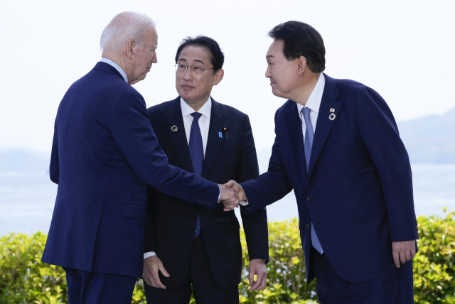 윤석열(오른쪽) 대통령과 조 바이든(왼쪽) 미국 대통령이 지난해 5월 21일 일본 히로시마에서 주요 7개국(G7) 정상회의를 계기로 열린 한미일 정상회담을 앞두고 기시다 후미오 일본 총리가 지켜보는 가운데 악수하고 있다.매일신문 DB