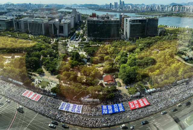 대한의사협회(의협)의 주도로 개원의와 일부 의대 교수들이 집단휴진에 나선 18일 오후 서울 영등포구 여의대로에서 열린 전국 의사 총궐기대회에서 의사들이 