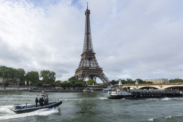 프랑스 파리 센강에서 펼쳐진 2024 파리 올림픽 리허설 도중 유람선과 경찰 고무보트가 에펠탑을 배경으로 지나가고 있다. 연합뉴스
