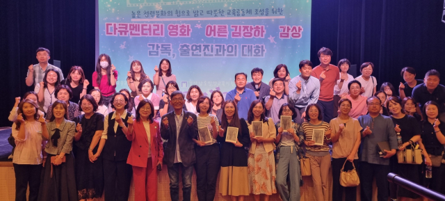 밀양교육지원청 김정희 교육장(사진 가운데 빨간 옷)이 직원 100여명과 함께 청렴문화연수 진행 후 포즈를 취하고 있다. 밀양교육지원청 제공