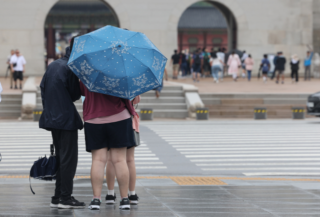 장마 영향으로 비가 내린 30일 오전 서울 종로구 광화문광장 일대에서 외국인 관광객들이 우산을 쓰고 이동하고 있다. 연합뉴스