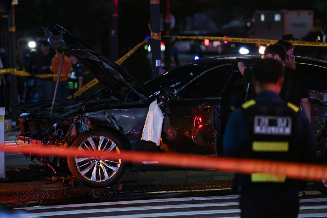 2일 오전 전날 대형 교통사고가 발생한 서울 시청역 인근 교차로에서 경찰이 완전히 파괴된 차량 한 대 주변을 통제하고 있다. 연합뉴스