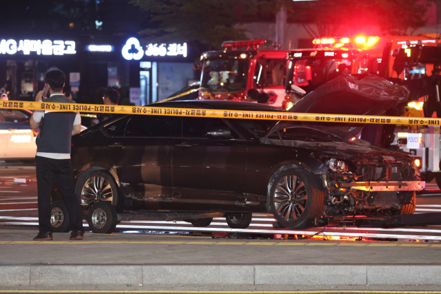2일 오전 전날 대형 교통사고가 발생한 서울 시청역 인근 교차로에서 경찰이 완전히 파괴된 차량 한 대 주변을 통제하고 있다. 연합뉴스