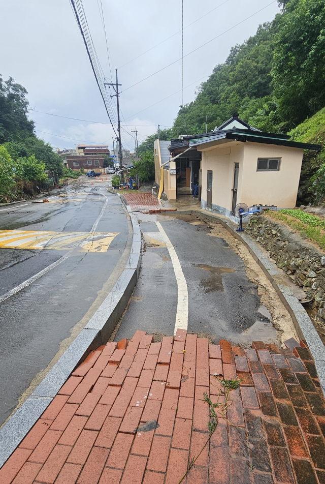 8일 밤 사이 많은 비가 쏟아지면서 안동시 용상 옛 성공동 일대 주택가 인도 보도블럭이 빗물에 쓸려 내려가 주택과 주차장 차량을 덮쳤다. 엄재진 기자