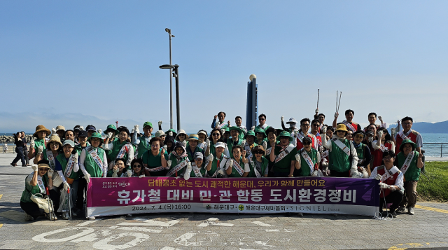 지난 4일 부산 해운대구 미포에서 청사포 몽돌해변 구간 그린레일웨이 일대에서 진행된 우수기와 휴가철 대비 민·관 합동 환경정비 행사에서 참여자들이 파이팅을 외치고 있다. [사진=해운대구]