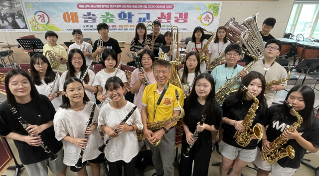 지난 22일 대구 불로중학교의 음악실. 문을 열고 들어서자 무게감 있고 웅장한 연주가 심장을 쿵쿵 울린다. 30여명의 학생들은 저마다 악기를 들고 음악에 흠뻑 빠져들었다. 그런데 그 사이로 보이는 희끗희끗한 머리가 유독 눈에 띈다. 바로 불로중 마칭밴드의 최고령 단원 현영철(61·앞줄 가운데) 교장이다.