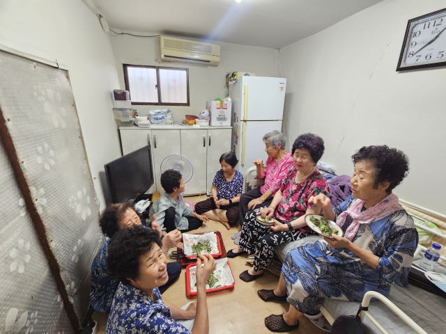 26일 오후 1시 반쯤 대구 서구 평리6동에 있는 구길자(가명·86) 할머니의 집에 모인 7명의 할머니가 전을 나눠 먹고 있다. 이날 서구 최고 기온은 33.2도로 무척 더웠다. 할머니들은 