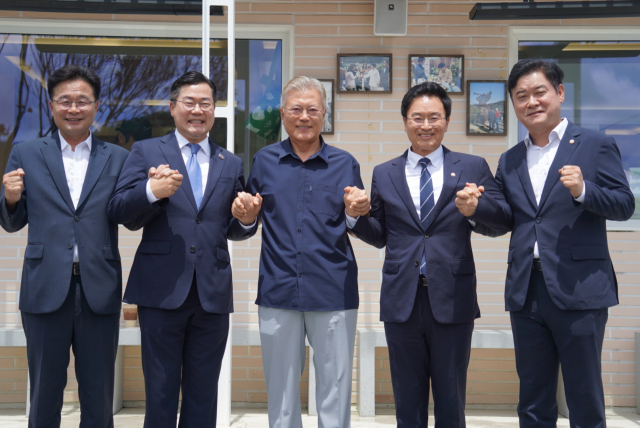 더불어민주당 박찬대 당대표 직무대행 겸 원내대표가 27일 경남 양산 평산마을에서 문재인 전 대통령과 기념촬영을 하고 있다. 연합뉴스