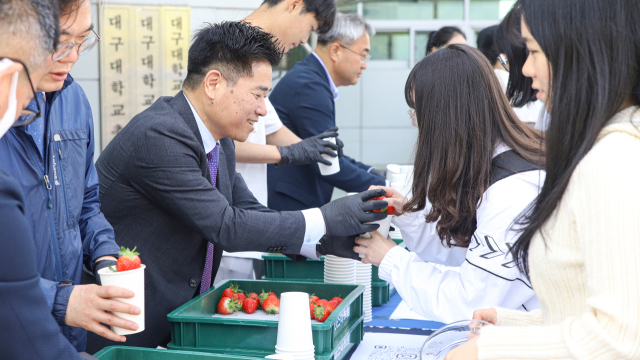 박순진 대구대 총장이 스마트팜 교육센터에서 재배한 딸기를 학생들에게 나눠주고 있다. 대구대 제공