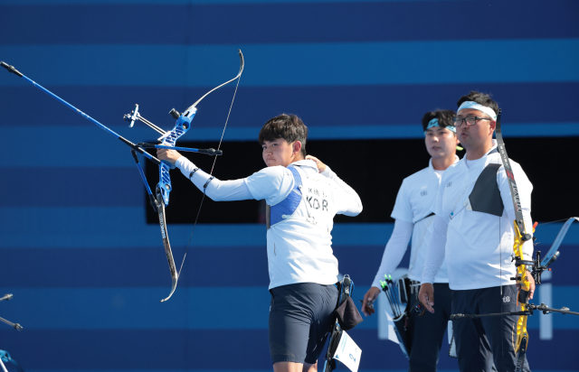 김제덕이 30일(한국 시간) 프랑스 파리 레쟁발리드 양궁 경기장에서 열린 2024 파리 올림픽 양궁 남자 단체 결승전 한국과 프랑스의 경기에서 활 시위를 놓은 뒤 과녁을 바라 보고 있다. 오른쪽부터 김우진, 이우석, 김제덕. 연합뉴스