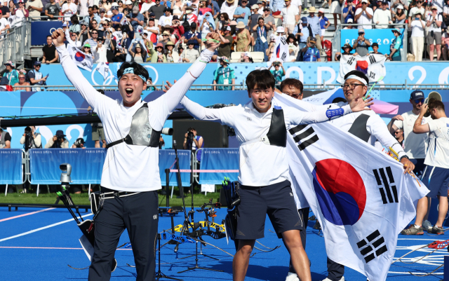 30일(한국 시간) 프랑스 파리 레쟁발리드 양궁 경기장에서 열린 2024 파리 올림픽 양궁 남자 단체 결승전에서 프랑스를 이기고 우승을 차지한 한국 대표팀 이우석(왼쪽부터), 김제덕, 김우진이 기뻐하고 있다. 연합뉴스