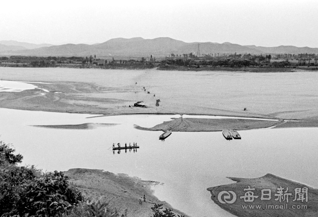 1970년대 달성군 화원동산에서 고령군 다산면 방향으로 내려다 본 낙동강. 백사장이 드넓게 펼쳐 진 가운데 뱃사공이 나룻배에 사람들을 태워 강을 건너고 있다. 사진=매일아카이빙센터