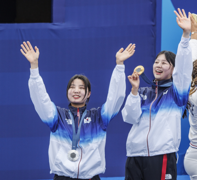 임시현(오른쪽)이 3일(한국 시간) 프랑스 파리 앵발리드에서 열린 2024 파리 올림픽 양궁 여자 개인전 결승에서 금메달을 딴 뒤 은메달을 획득한 남수현(왼쪽)과 시상대에서 인사를 하고 있다. 연합뉴스