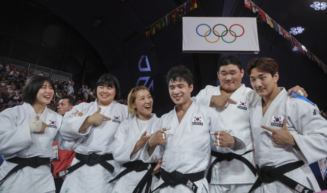 한국 선수들이 4일(한국 시간) 프랑스 파리 샹드마르스 경기장에서 열린 2024 파리 올림픽 유도 혼성 단체전 동메달 결정전을 승리로 이끈 뒤 도복의 태극기를 가리키며 승리를 자축하고 있다. 왼쪽부터 허미미, 김하윤, 김지수, 안바울, 김민종, 이준환. 연합뉴스