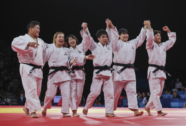 한국 선수들이 4일(한국 시간) 프랑스 파리 샹드마르스 경기장에서 열린 2024 파리 올림픽 유도 혼성 단체전 동메달 결정전을 승리로 이끈 뒤 함께 손을 들며 환호하고 있다. 왼쪽부터 김민종, 김지수, 허미미, 안바울, 김하윤, 이준환. 연합뉴스