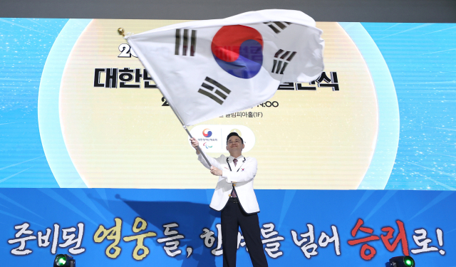 12일 오후 서울 송파구 올림픽파크텔에서 열린 2024 파리 패럴림픽 대회 결단식에서 배동현 선수단장이 정진완 대한장애인체육회장에게 단기를 수여 받은 뒤 힘차게 흔들고 있다. 연합뉴스