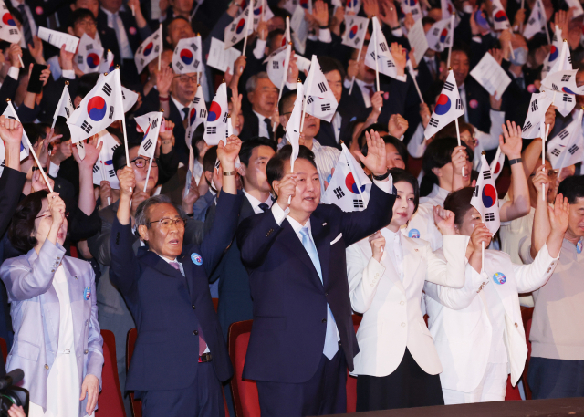 윤석열 대통령과 김건희 여사가 지난 8월 15일 서울 세종문화회관에서 열린 제79주년 광복절 경축식에서 이동일 순국선열유족회장 등 참석자들과 만세삼창을 하고 있다. 연합뉴스