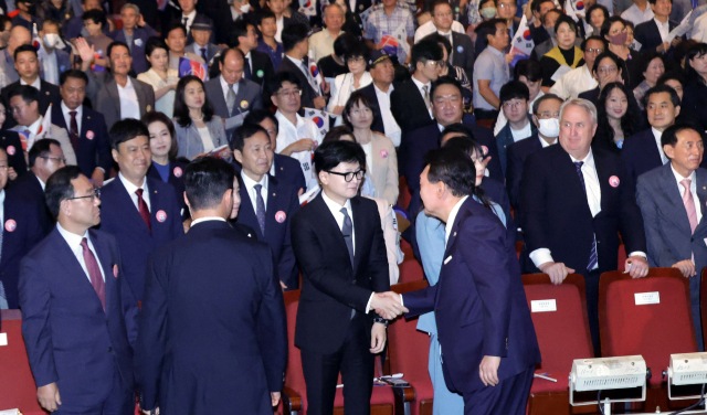 윤석열 대통령이 15일 서울 종로구 세종문화회관에서 열린 제79주년 광복절 경축식에서 퇴장하며 국민의힘 한동훈 대표와 악수하고 있다. 연합뉴스