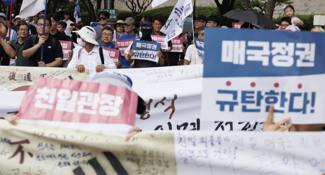 제79주년 광복절인 15일 항일독립선열 선양단체 연합(항단연)이 서울 용산구 효창공원 내 삼의사 묘역에서 개최한 광복절 기념식을 마친 참석자들이 독립기념관장 임명 철회 등을 요구하며 행진을 하고 있다. 연합뉴스