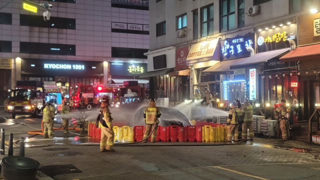 16일 경기 용인시 기흥구 구갈동 한 도로에 주차된 테슬라에서 불이 나 소방 대원들이 진화 작업을 벌이고 있다. 경기도소방재난본부 제공