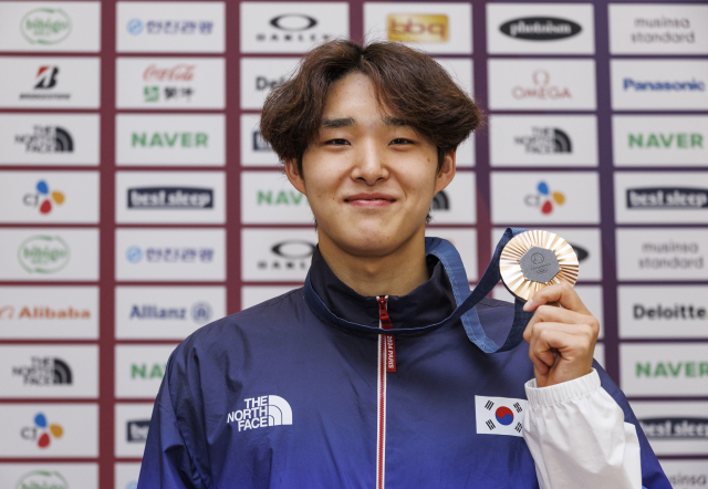 2024 파리올림픽 수영 남자 400m 자유형에서 3위를 기록 동메달을 획득한 김우민이 5일 오전(현지시간) 파리 중심에 설치된 코리아하우스에서 열린 기자회견에서 메달을 들고 미소짓고 있다. 연합뉴스