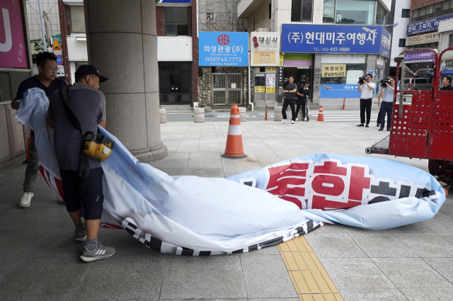 28일 오후 대구시청 동인청사에서 현수막 업체 관계자가 외벽에 붙어있던 대구·경북 행정통합 관련 홍보 현수막을 철거하고 있다. 김영진 기자 kyjmaeil@imaeil.com