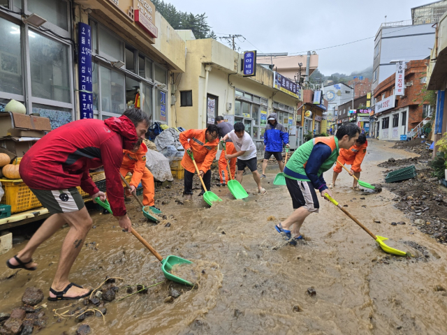 12일 울릉도에 내린 호우로 인해 큰 피해가 발생했다. 마을주민과 함께 외국인 관광객이 자발적으로 나서 복구작업을 진행하고 있다.조준호 기자