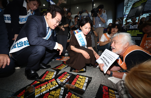 더불어민주당 이재명 대표가 13일 오전 서울 용산역에서 추석 귀성인사를 하던 도중 박경석 전국장애인차별철폐연대(전장연) 대표의 7대 장애인권리입법 제정 호소를 듣고 있다. 연합뉴스