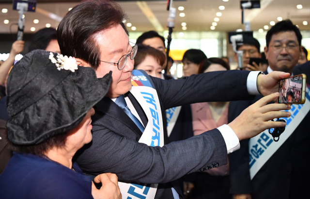 더불어민주당 이재명 대표가 추석 연휴를 하루 앞둔 13일 오전 서울 용산역에서 귀성길에 오른 시민들과 셀카를 찍고 있다. 연합뉴스