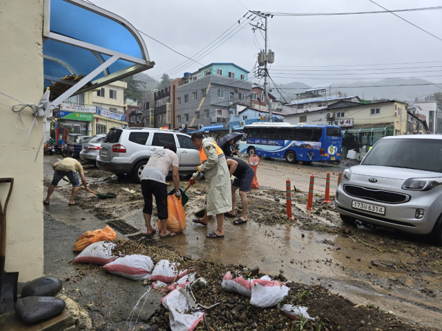 물폭탄을 맞은 울릉군. 12일 오후부터 전 행정력을 동원해 응급복구작업중이다. 저동지역 버스승강장 주변지역을 주민이 자발적으로 나서 응급복구를 하고 있다.조준호 기자