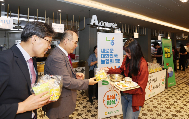 홍원화 경북대 총장(가운데)과 이청훈 농협중앙회 대구본부장이 농협이 준비한 식혜와 쌀과자를 아침식사하는 학생들에게 나눠주고 있다.