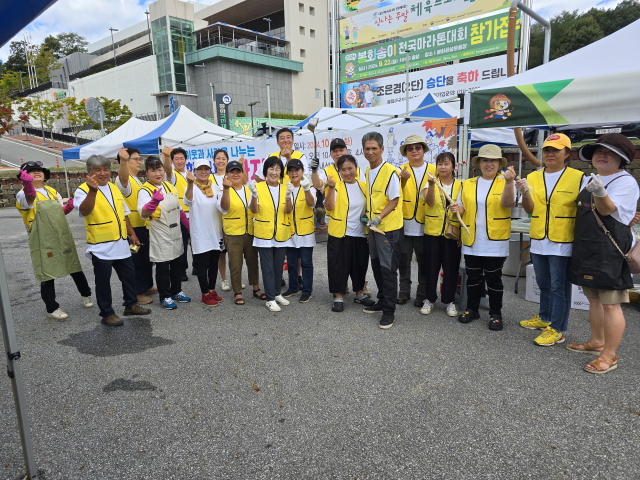 봉화군귀농귀촌연합회 회원들이 22일 제12회 봉화송이 전국마라톤 대회에서 방문객을 대상으로 한 잔치국수 나눔 봉사활동을 진행하기에 앞서 손가락으로 하트 모양을 만든 후 기념 촬영하고 있다. 김영진 기자