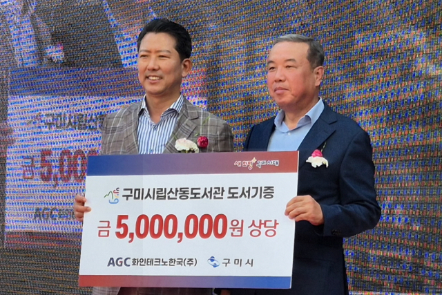 김재근(오른쪽) AGC화인테크노한국㈜ 대표이사가 김장호 구미시장에게 500만원 상당의 도서를 기증한 뒤 기념촬영을 하고 있다. AGC화인테크노한국 제공