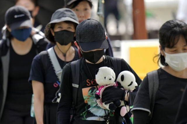 일본 도쿄 우에노동물원에 살던 자이언트 판다 리리와 싱싱의 배웅을 나온 일본 시민들.AP 연합뉴스