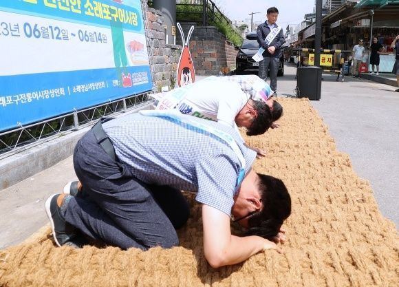 지난해 6월14일 인천시 남동구 소래포구 전통어시장에서 상인들이 자정대회를 열고 신뢰 회복을 약속하며 사과하는 모습. 연합뉴스