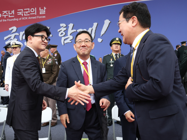 국민의힘 한동훈 대표(왼쪽)가 1일 성남 서울공항에서 열린 건군 76주년 국군의날 기념식에 참석해 더불어민주당 박찬대 원내대표와 인사하고 있다. 가운데는 주호영 국회부의장. 연합뉴스