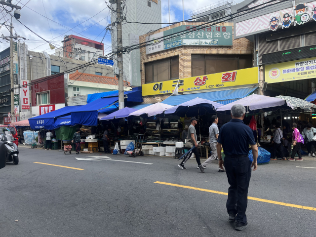 지난달 28일 방문한 관문시장. 방문객들이 노점을 피해 차도 위로 통행하자, 차들이 경적을 울리는 일이 반복됐다.