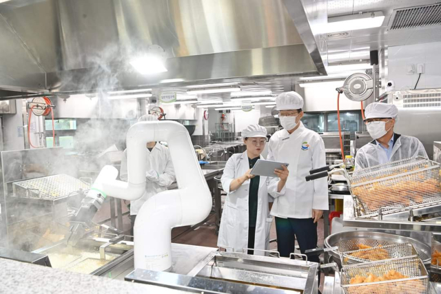 임종식 경북교육감이 포항고등학교에 시범 도입된 튀김 로봇의 구동 과정을 확인하고 현장 관계자들과 소통하며 운영에 대한 전반적인 현황을 파악하고 있다. 경북교육청 제공