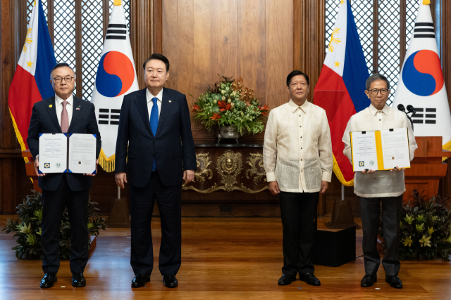 황주호 한국수력원자력 사장과 라파엘 로띨리야 필리핀 에너지부 장관이 7일 오전(현지시간) 필리핀 마닐라 말라카냥 대통령궁에서 윤석열 대통령과 페르디난드 마르코스 필리핀 대통령이 임석한 가운데 한·필리핀 바탄 원전 건설 재개 타당성 조사 협력에 관한 양해각서(MOU)를 교환한 뒤 기념촬영을 하고 있다. 연합뉴스