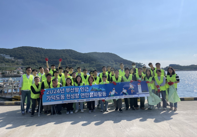 지난 11일 부산 강서구 가덕도 천성항 일대에서 부산항만공사 임직원과 부산항 신항 터미널 운영사 관계자 등이 연안정화 활동을 벌인 후 기념촬영을 하고 있다. [사진=BPA]