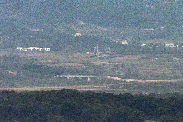 북한이 경의선과 동해선 도로 폭파를 준비하는 정황이 우리 군 감시장비에 포착된 가운데 14일 경기도 파주시 접경지역에서 바라본 서부전선 비무장지대(DMZ) 북측 지역의 경의선 도로 위 구조물 인근에 흙더미가 쌓여 있다. 연합뉴스