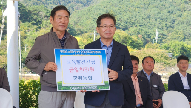 최형준(왼쪽) 대구 군위농협 조합장이 김진열(오른쪽) 군위군수에게 교육발전기금을 전달하고 기념 사진을 촬영하고 있다. 군위군 제공