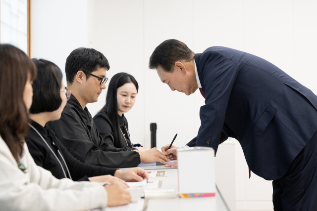 윤석열 대통령이 서울시교육감 보궐선거 투표 날인 16일 서울 용산구 용산공예관 투표소에서 본인 확인 뒤 서명하고 있다. 연합뉴스