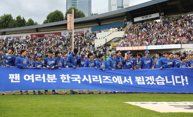 삼성 라이온즈 선수들이 19일 서울 잠실구장에서 열린 2024 프로야구 포스트시즌 플레이오프 4차전에 출전해 LG 트윈스를 꺾고 한국시리즈 진출을 확정한 뒤 그라운드에서 현수막을 펼쳐 보이며 기뻐하고 있다. 연합뉴스