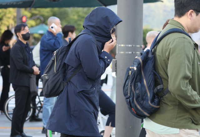 쌀쌀한 날씨를 보인 2일 오전 서울 종로구 광화문네거리에서 한 시민이 추위에 웅크리고 있다. 연합뉴스